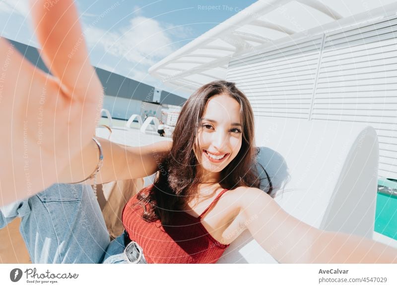 Selfie, Lifestyle concept. Close up of young african charming curly haired woman in red tshirt smiling with teeth, taking selfie, chatting with boyfriend on phone.