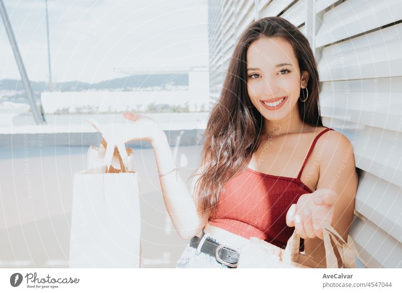 Beautiful young african woman with shopping bags on city street mall. Copy space, Christmas new year shopping presents concept, new clothes shopping day. Modern styling and young woman concepts