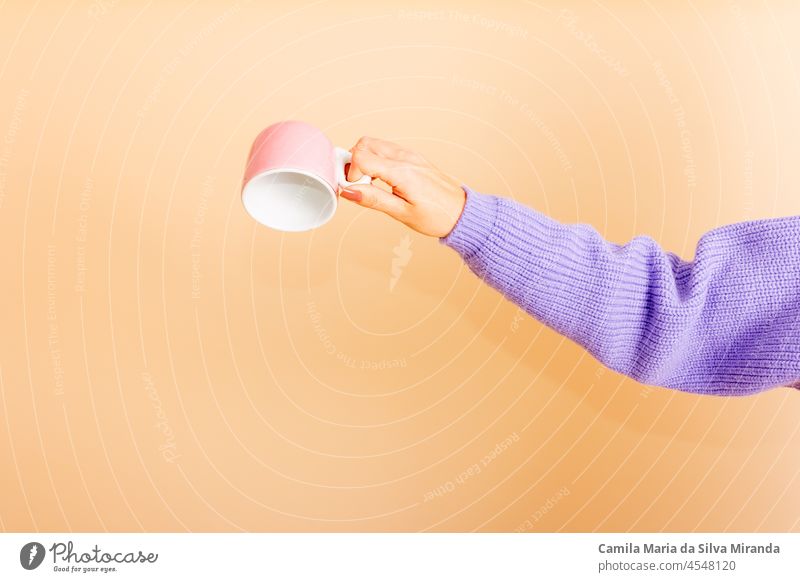 Closeup of female hands turning the cup. Girl with beautiful nails. holding cup of tea or coffee. Studio photo. Photo for cropping. Empty. autumn background