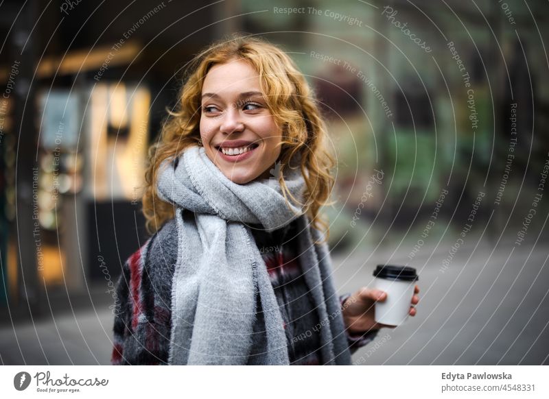 Young woman walking on the city street holding cup of coffee one person adult beautiful casual female girl people lifestyle urban attractive town portrait young