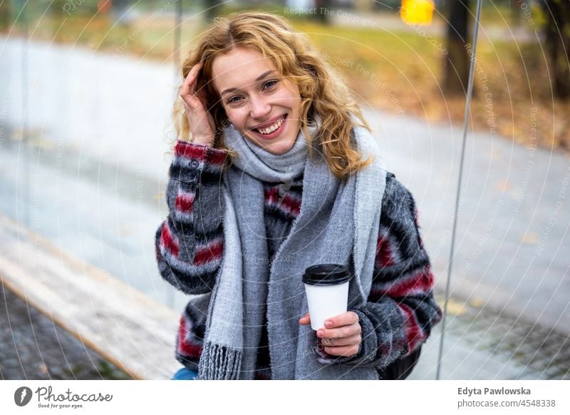 Young woman with coffee cup smiling outdoors one person adult beautiful casual female girl people lifestyle urban city street attractive town portrait young