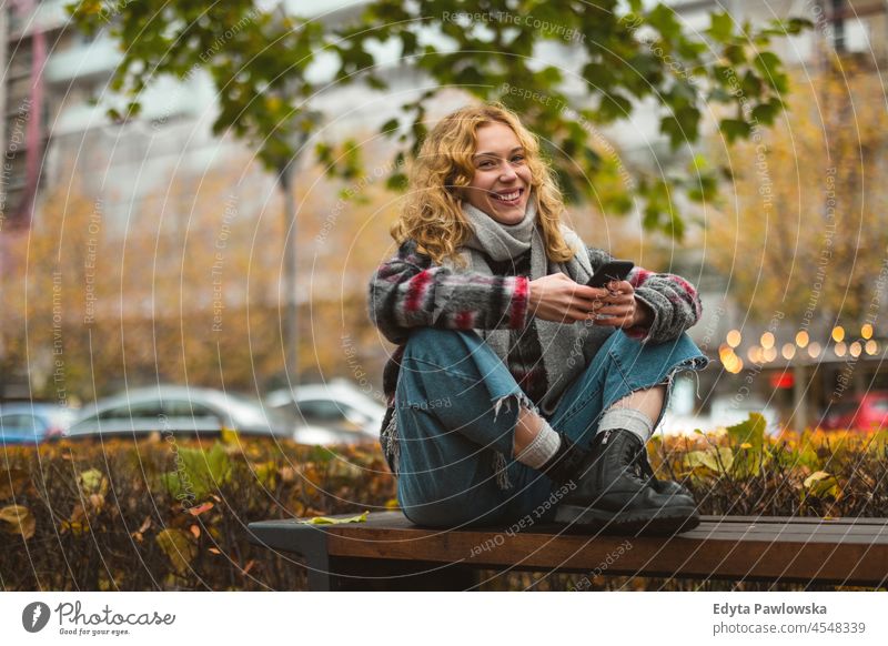 Young woman in the city checking her mobile phone one person adult beautiful casual female girl people lifestyle urban street attractive town portrait young