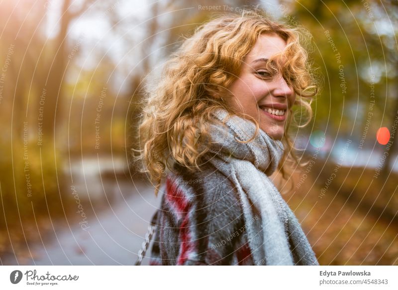 Happy young woman in autumn park one person adult beautiful casual female girl people lifestyle urban city street attractive town portrait millennials Warsaw