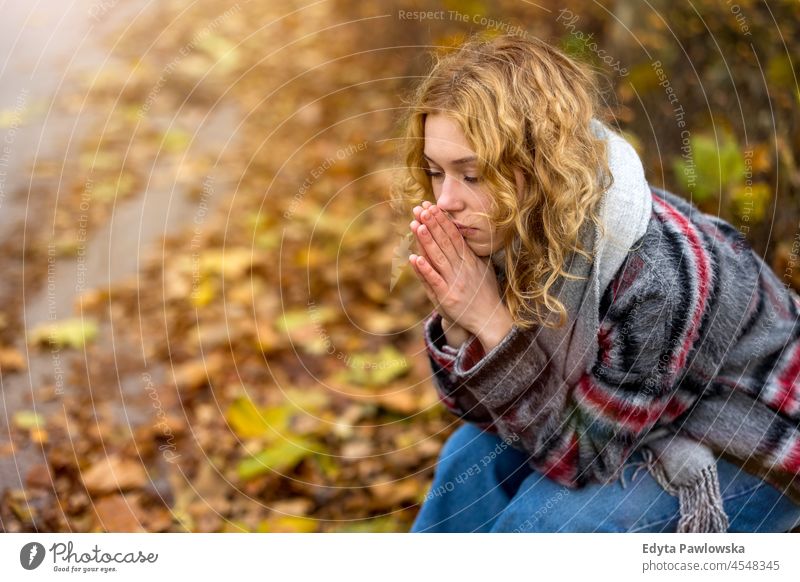 Young woman sitting on bench in a public park one person adult beautiful casual female girl people lifestyle urban city street attractive town portrait young