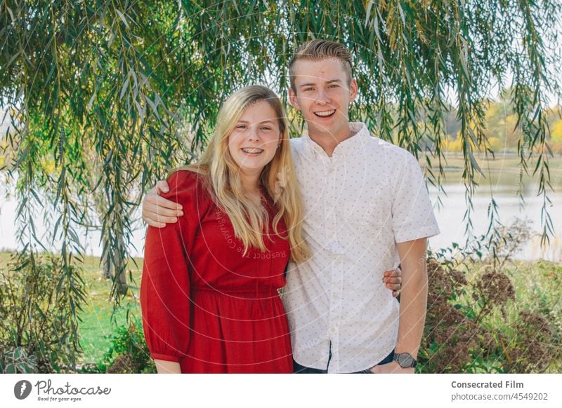 Couple of friends hugging, happy smiling at the camera lifestyle together Happy Joy campus students Student graduation vines lake mountains family female