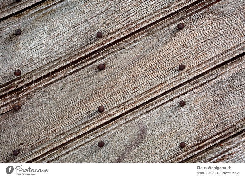 Detail of an ornate, old, weathered wooden door with rows of rusty nails Nail Wood Board Weathered Old Craft (trade) Rust Diagonal Adornment Ornate Safety