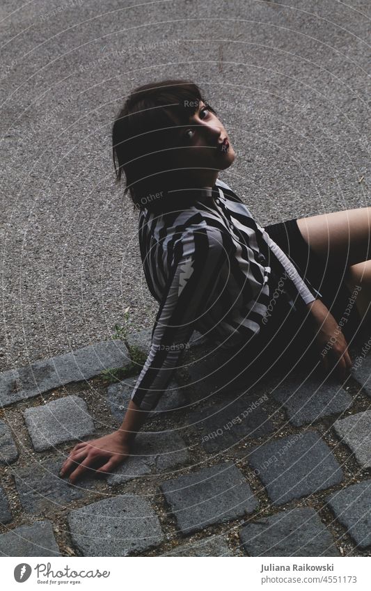 Woman sitting on the street fashionable Clothing Day Stripe Ground Sit Asphalt Blouse fashion photography City Street Hip & trendy Lifestyle Fashion Design