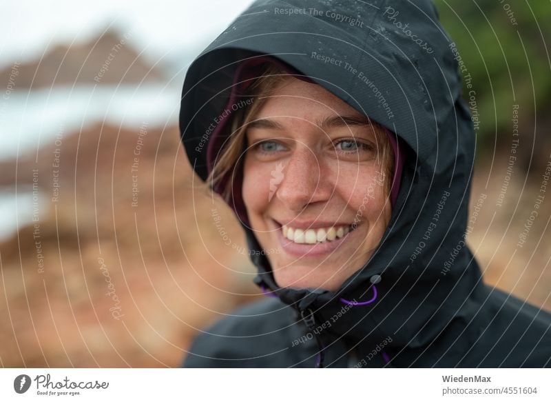 Joy in autumn storm by the sea Autumn Rain Wind Gale Laughter Rain jacket Ocean coast Rock Young woman Happy