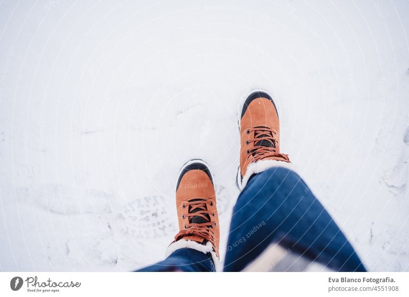 unrecognizable female feet boots walking on snowy landscape during winter. hiking concept, top view legs woman alone modern equipment nature mountain close up