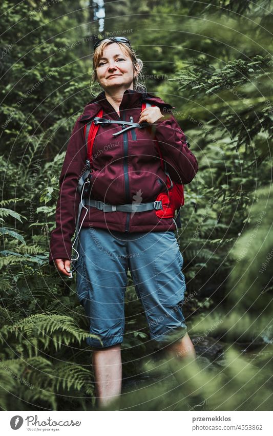 Woman with backpack hiking in forest, actively spending summer vacation close to nature adventure trip travel journey trekking woman mountain wanderlust walking