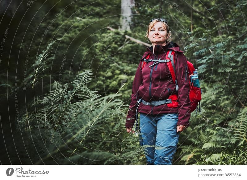 Woman with backpack hiking in forest, actively spending summer vacation close to nature adventure trip travel journey trekking woman mountain wanderlust walking