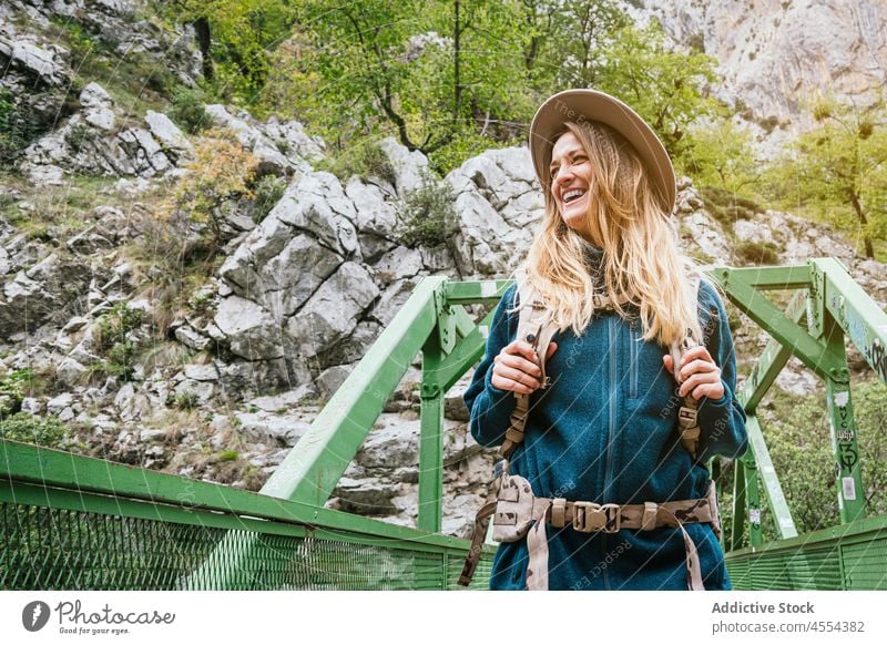 Woman walking on bridge in mountainous terrain woman tourist admire nature explore cliff rocky trekking female backpack highland landscape tourism traveler