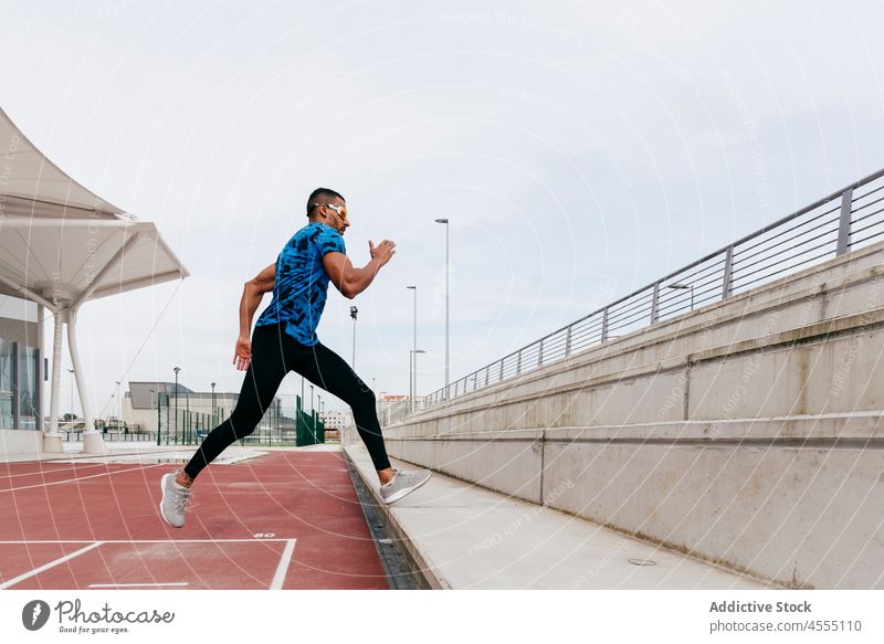 Fit man exercising on the field track handsome male ethnic african young adult athlete sportswear running runner training fitness exercise healthy lifestyle