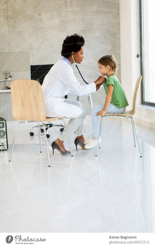 Cute little girl at the pediatrician examination african american black care checking child children clinic daughter disease doctor family female health