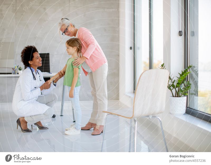 Cute little girl with her grandmother at the pediatrician examination african american black care checking child children clinic daughter disease doctor family