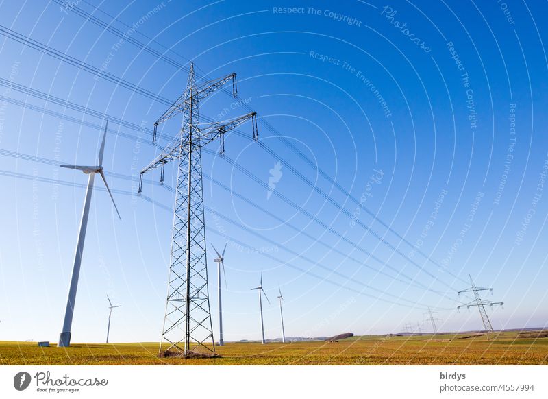 Wind turbines next to a power line, overhead power line. Wind farm, power transmission Wind energy plant wind farm Renewable energy High voltage power line