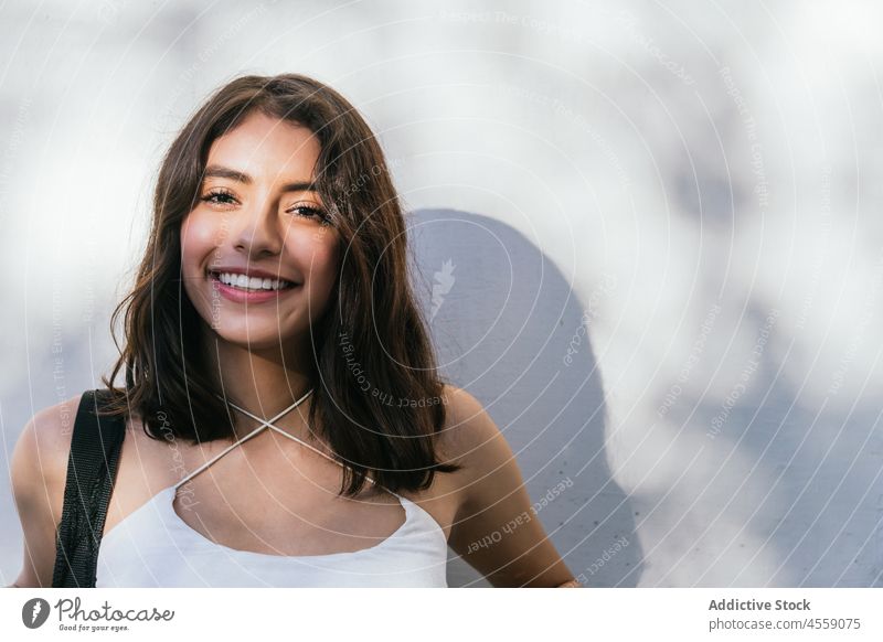 Positive brunette on white background woman portrait content smile cheerful expressive delight positive happy pleasant female hispanic joy ethnic carefree