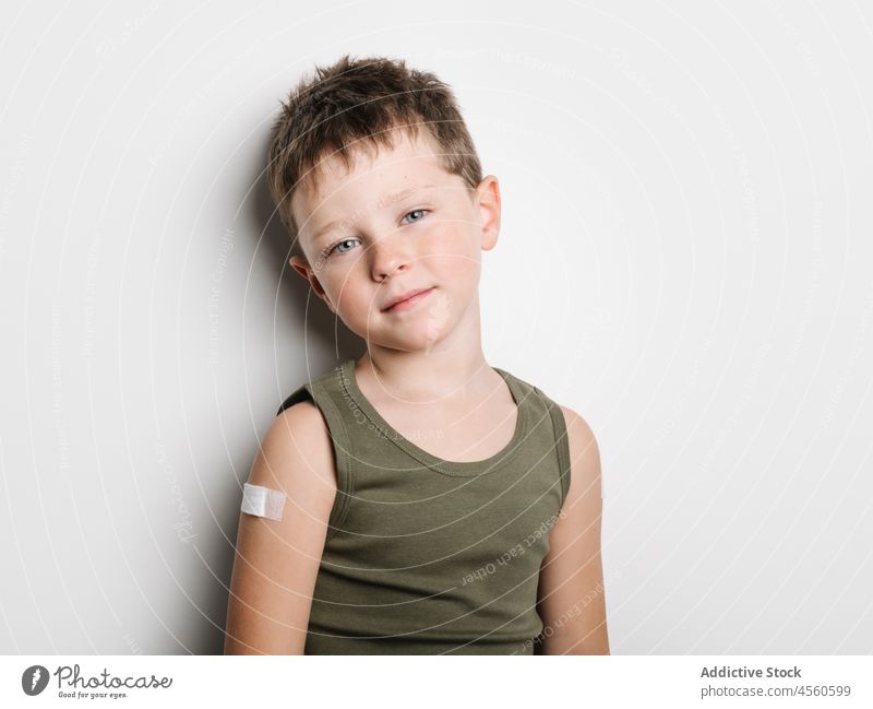 Schoolboy after vaccination with band aid on arm child vaccine jab kid shot injection healthy motivation childhood support medical epidemic schoolkid generation