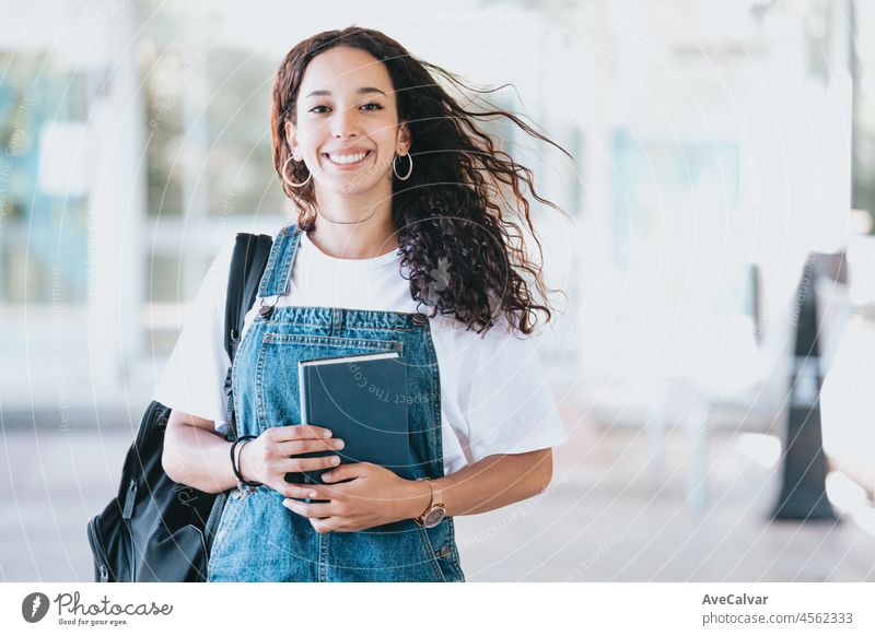 African student with backpack carrying books after study. Portrait of young african woman. Education concept. Trendy fashion style, holds a backpack, copy space. Smiling to camera