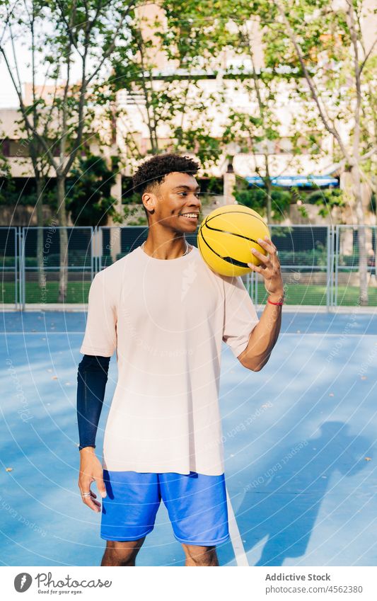 Happy black basketball player holding ball man sport training sportsman game stadium activewear sports ground motivation confident ethnic concentrate smile