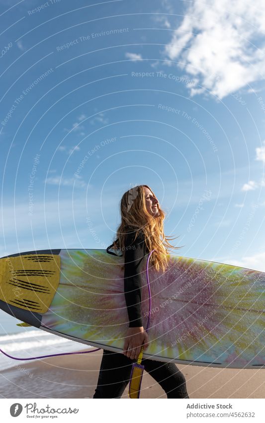 Woman with surfboard walking on wet beach woman coast shore hobby cheerful activity pastime happy sport sea smile water tide wave waterfront seaside nature