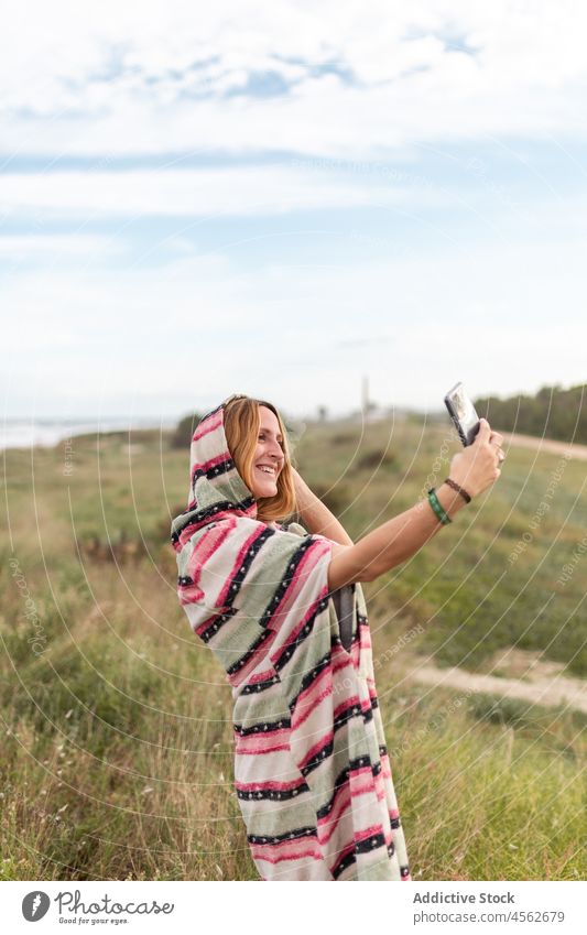 Cheerful woman taking selfie in nature smartphone self portrait capture photography pastime leisure recreation grass moment female lady smile mobile cheerful