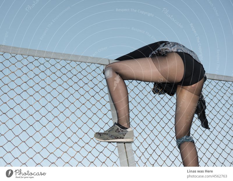 Wild girl feeling some punk rock, rock & roll, or just having some fun while climbing a rusty fence. Showing off her pretty long legs, black lingerie, and a feeling of fashion. Looking once more at the image it reminds me of “Scar Tissue” for some reason.