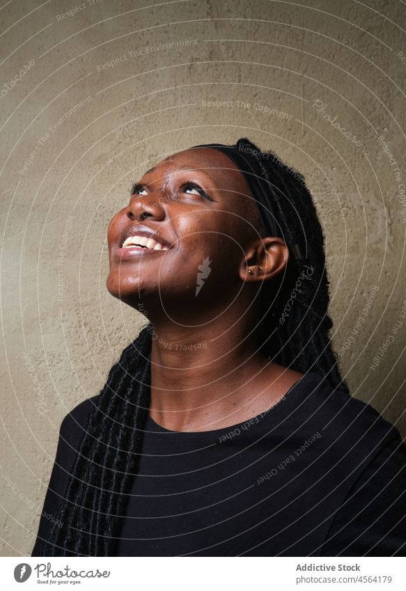 Smiling black female sitting on floor in studio woman cheerful positive smile appearance hairstyle happy glad toothy smile optimist african american casual