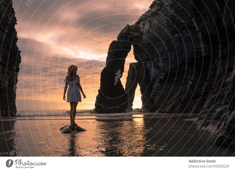 Female standing on rock in seawater in evening woman sundown sunset twilight cliff picturesque mountain shallow admire beach of the cathedrals galicia spain