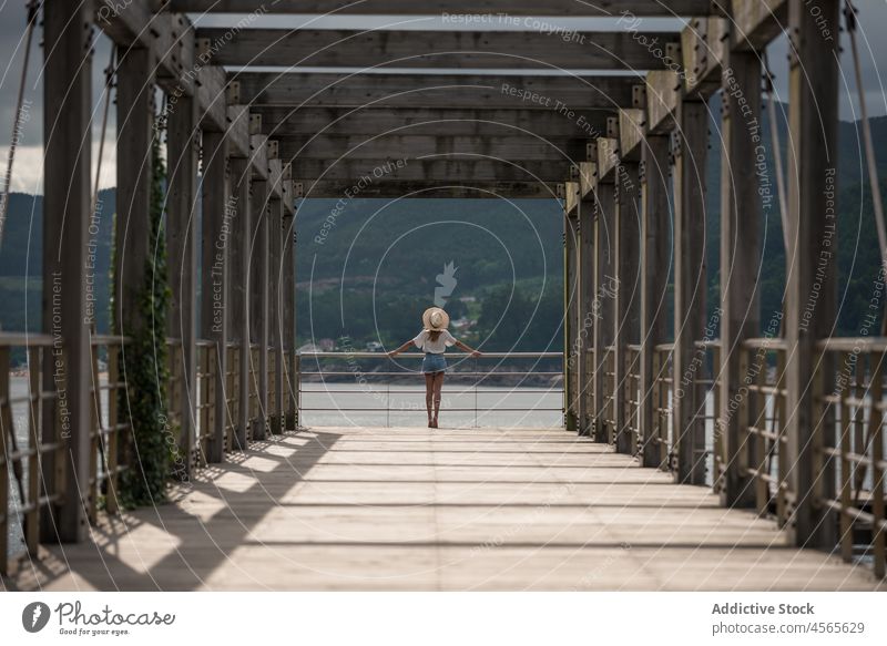 Female traveler on wooden pier near sea woman tourist observe sky cloudy fence seascape construction overcast boardwalk gloomy railing cargadero da insua spain