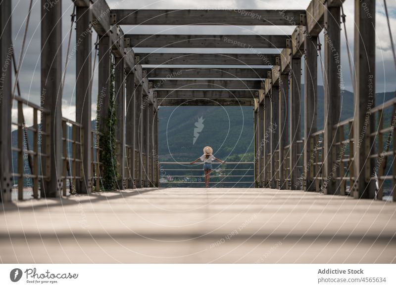 Female traveler on wooden pier near sea woman tourist observe sky cloudy fence seascape construction overcast boardwalk gloomy railing cargadero da insua spain