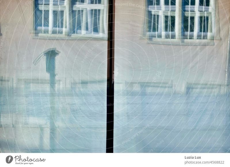 The window panes of an empty street café and the foils hanging behind them reflect the façade opposite. Glass Pane Window pane vacant depends Concealed Slice