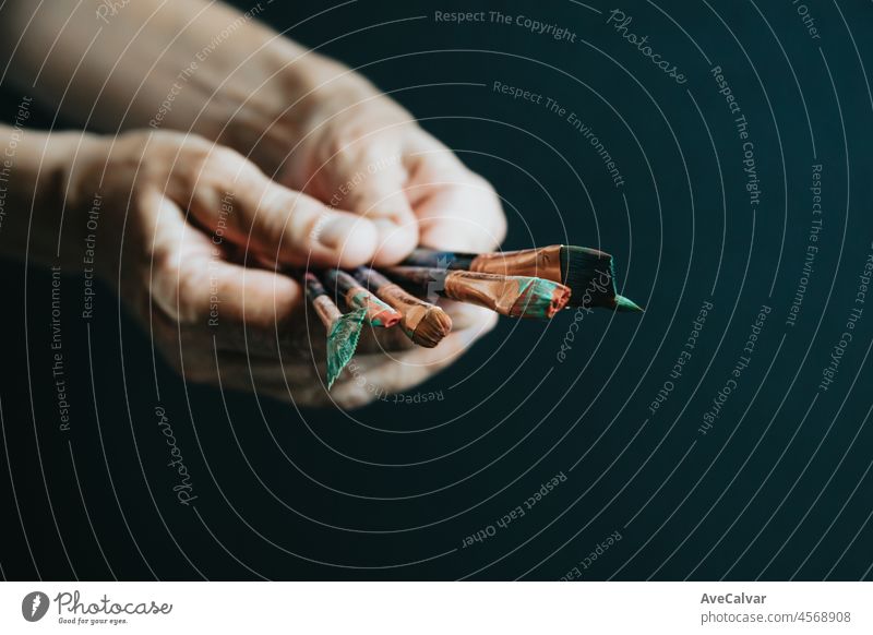 Old woman artist hands filled with paint pencils and brushes, ready for painting acrylic. Artistic concepts, artist concept. Dark background copy space canvas