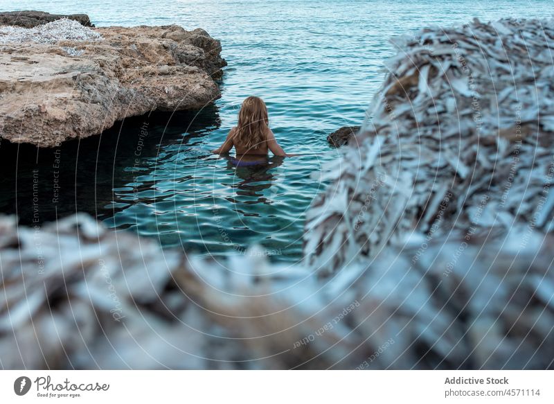 Unrecognizable woman swimming in sea near rocky coast water shore trip vacation rest tourist traveler nature journey tourism stone summer female ripple