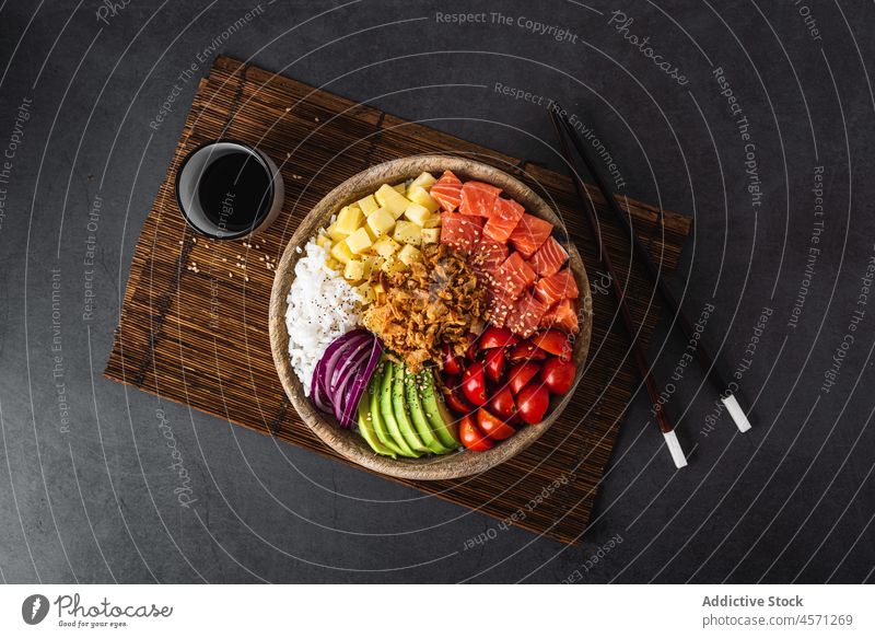 Delicious poke bowl with assorted veggies rice and salmon served with soy sauce food avocado tomato mango asian food healthy food onion dish cuisine fish meal