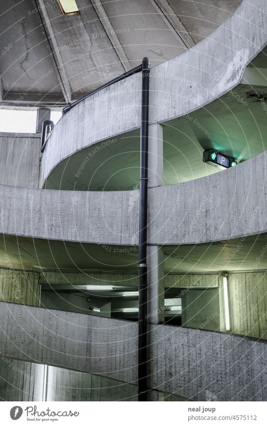 Interior view driveway parking garage in exposed concrete aesthetics Architecture Concrete Parking garage Trashy urban Old Neon light shabby Gray