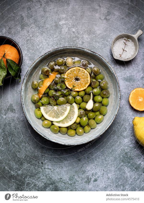 Tasty olives in brine in bowl placed on table delicious restaurant lemon food serve tasty yummy portion gourmet fresh cuisine culinary slice gastronomy