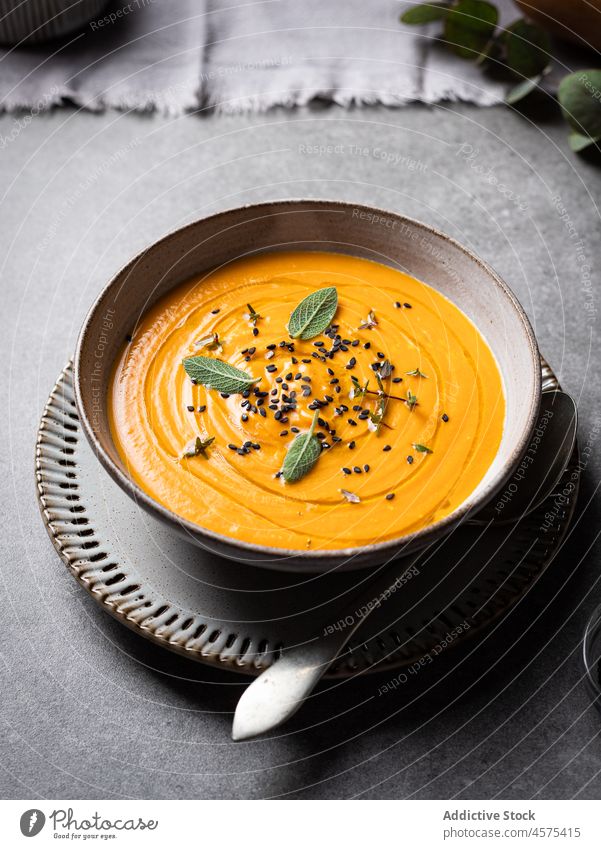 Tasty pumpkin soup placed on a plate on a table on a tabletop bowl delicious vegetable gourmet tasty cuisine food yummy spoon serve healthy food nutrition