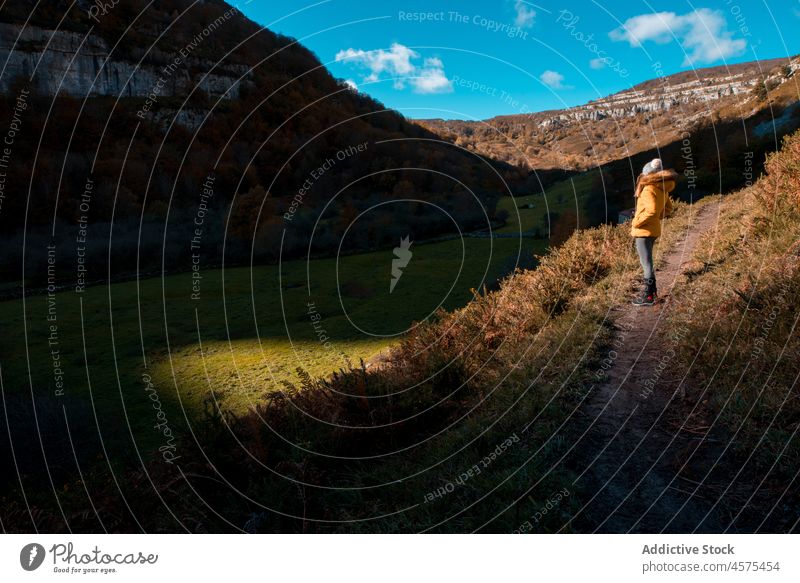 Unrecognizable traveler standing on path against mountains woman hiker nature footpath trekking autumn female explore trip wanderlust adventure spain meadow