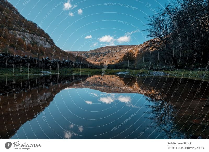 Serene lake near mountains in autumn nature landscape pond picturesque peak ridge blue sky scenery calm spectacular spain cantabria grass slope terrain water