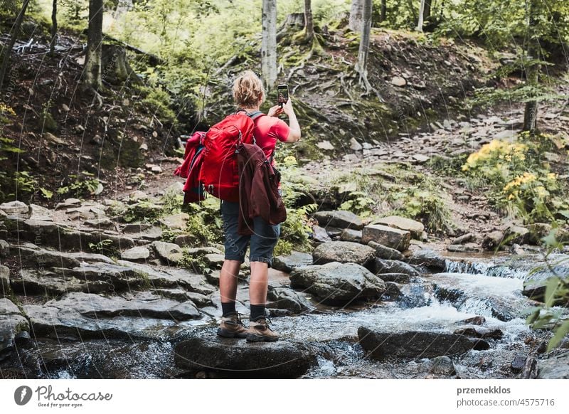 Taking pictures from vacation. Woman with backpack taking photos of landscape using smartphone camera summer trip mountain travel journey adventure hiking