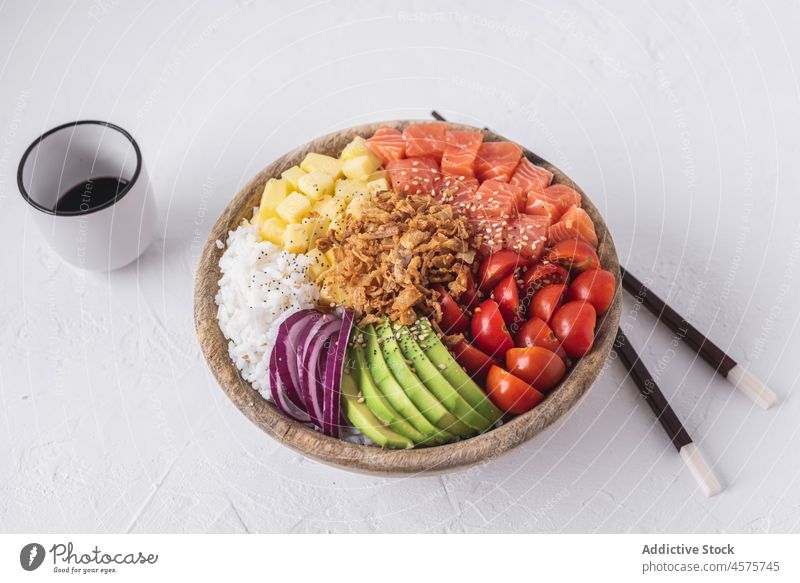 Poke bowl and soy sauce poke raw dish ingredient chopstick food fresh tradition hawaiian cuisine salmon fish portion seafood tomato cherry avocado onion rice