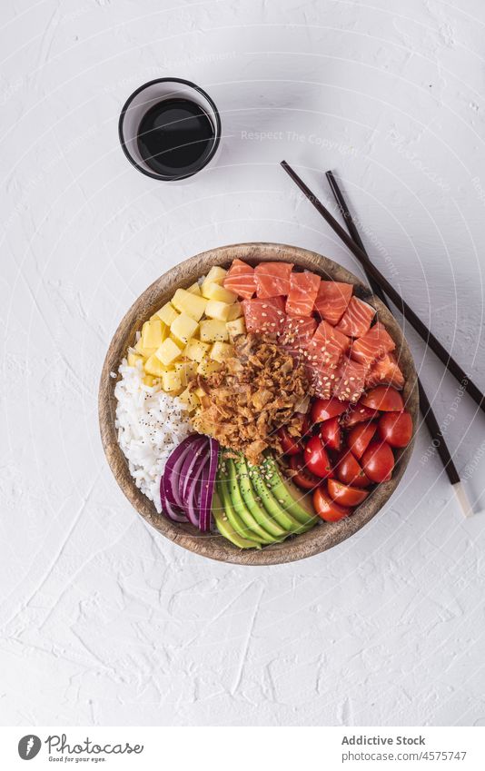 Poke bowl and soy sauce poke raw dish ingredient chopstick food fresh tradition hawaiian cuisine salmon fish portion seafood tomato cherry avocado onion rice