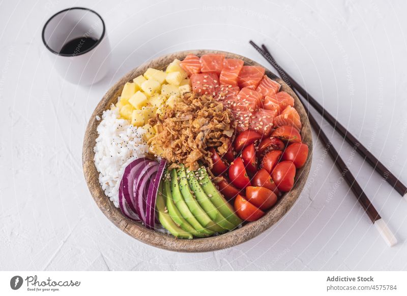 Poke bowl and soy sauce poke raw dish ingredient chopstick food fresh tradition hawaiian cuisine salmon fish portion seafood tomato cherry avocado onion rice