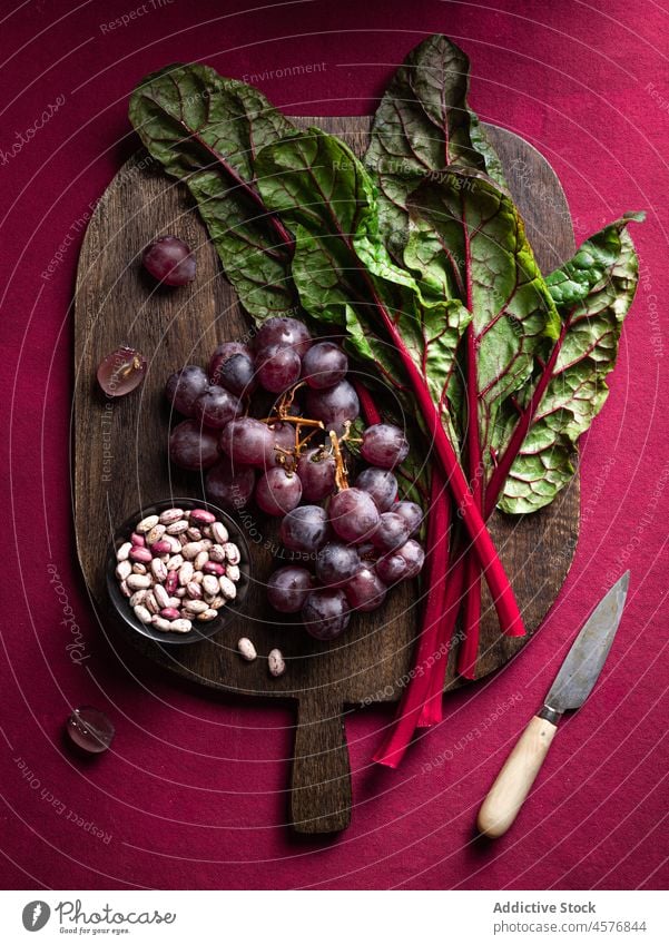 Chard with grapes on table chard vegetable healthy food vitamin organic bean assorted raw plate natural fresh pile heap stem vivid many botanic bunch legume