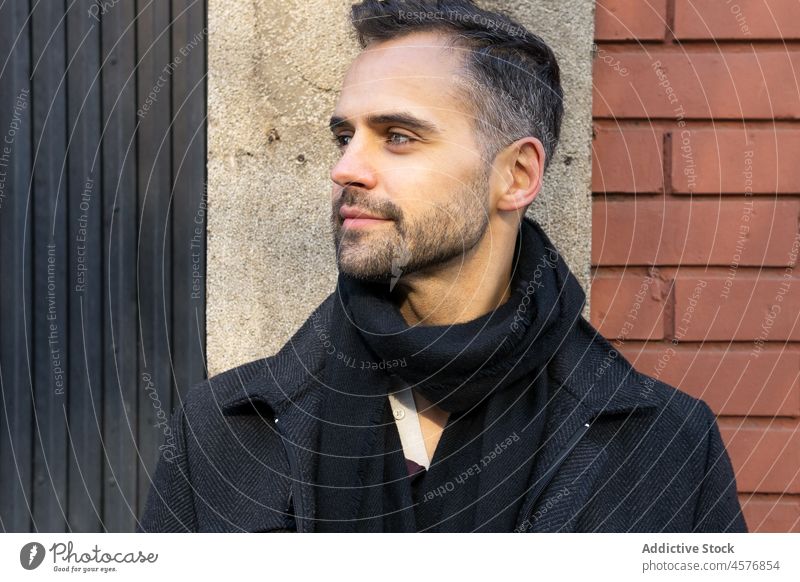 Serious male looking away against building in daytime man serious street calm coat city urban exterior pensive construction structure casual guy stand town