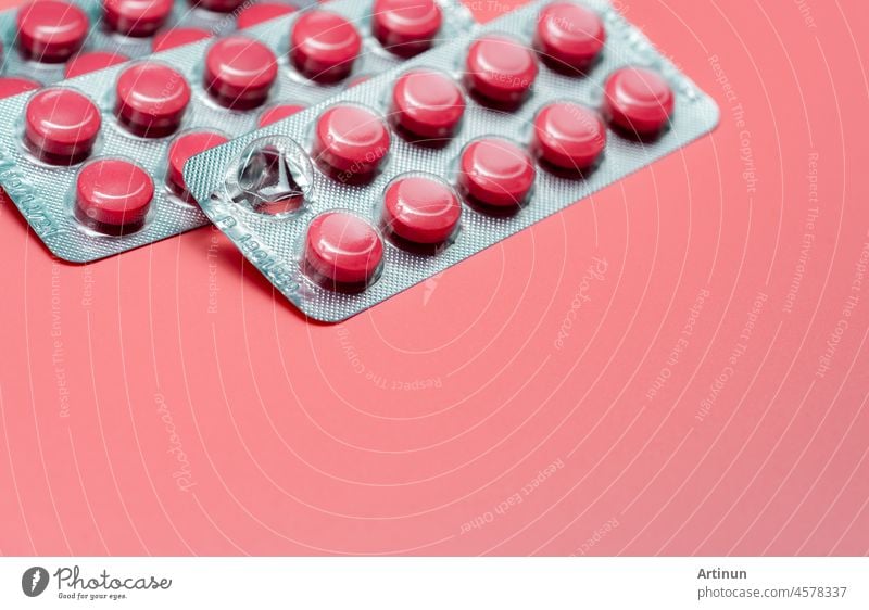 Pink round tablets pills in blister pack on pink background. Painkiller medicine. Take pill. Pharmacy product package. Pharmaceutical industry. Prescription drugs. Tablets pills for relieve pain.