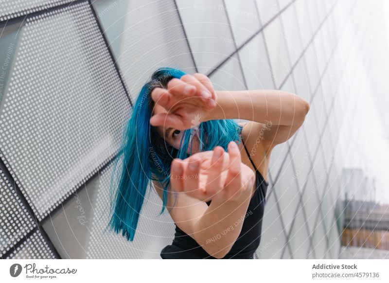 Confident female performing dance near wall of modern building woman hobby choreography portrait charming arms raised dancer appearance trendy style street glad