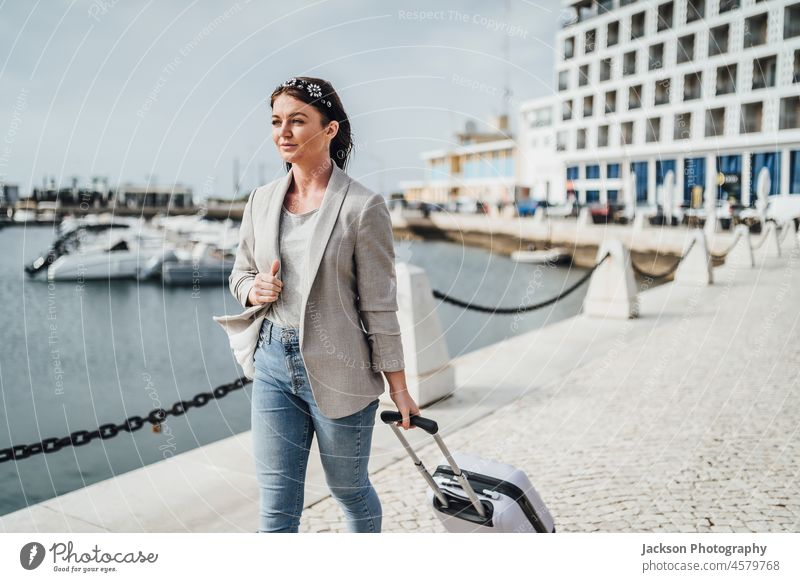 Young woman with a suitcase walking in urban settings. travel bag tourist adventure algarve freedom young british backpacker natural pavement street portrait