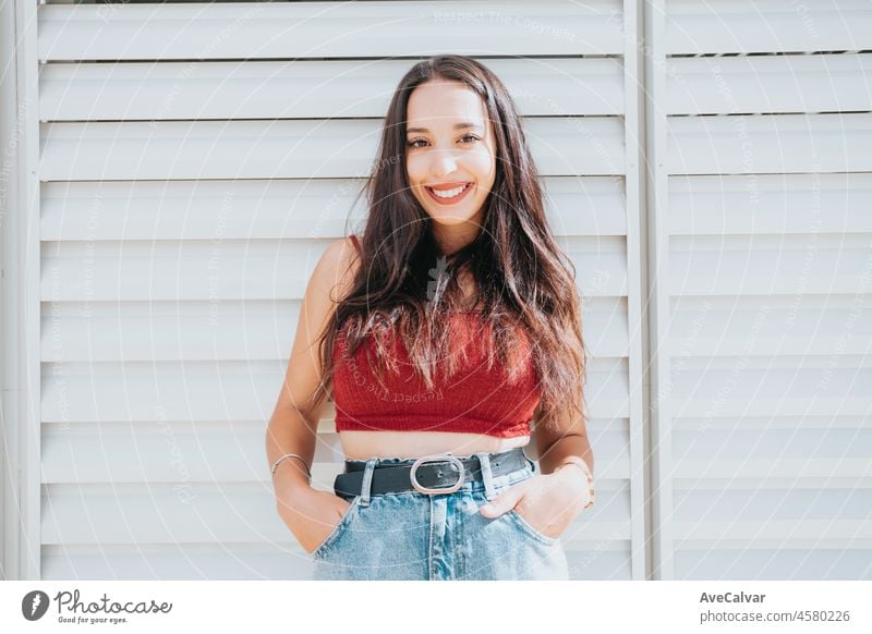 Portrait of a young african american cute girl in red top with a smile in the mall. Attractive girl smiling in the mall during shopping and looking at the camera, Good vibes blue jeans.